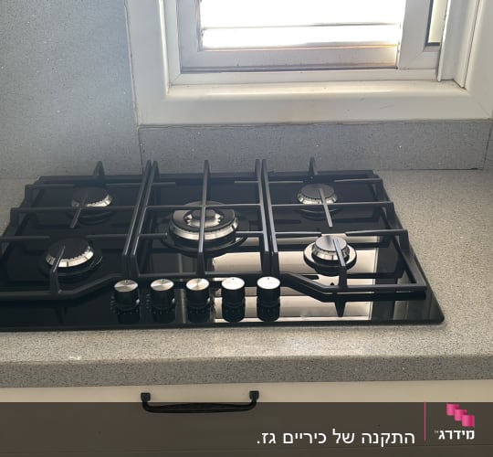 כיריים גז במטבח ליד חלון